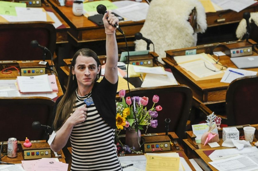 Representative Zephyr holding her microphone up in solidarity with protesters at the Montana legislature.