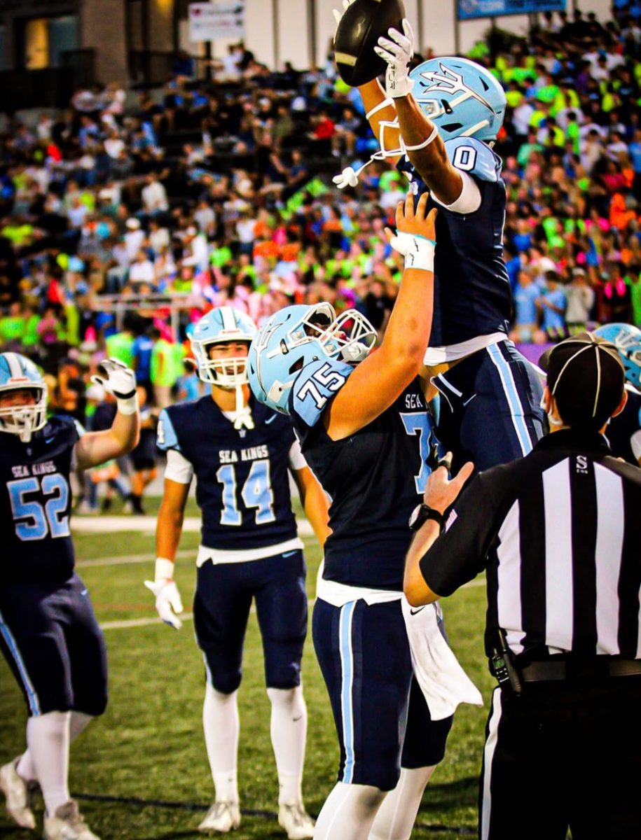 CdM football players celebrating a touchdown, student section riled up in the back with their neon attire.

Photo courtesy of @parwizpics on Instagram